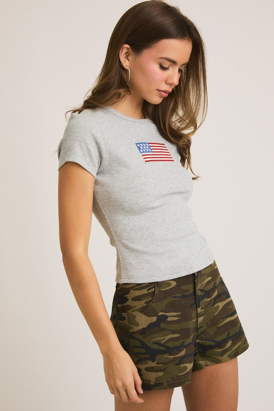 Woman in grey shirt and camo shorts.