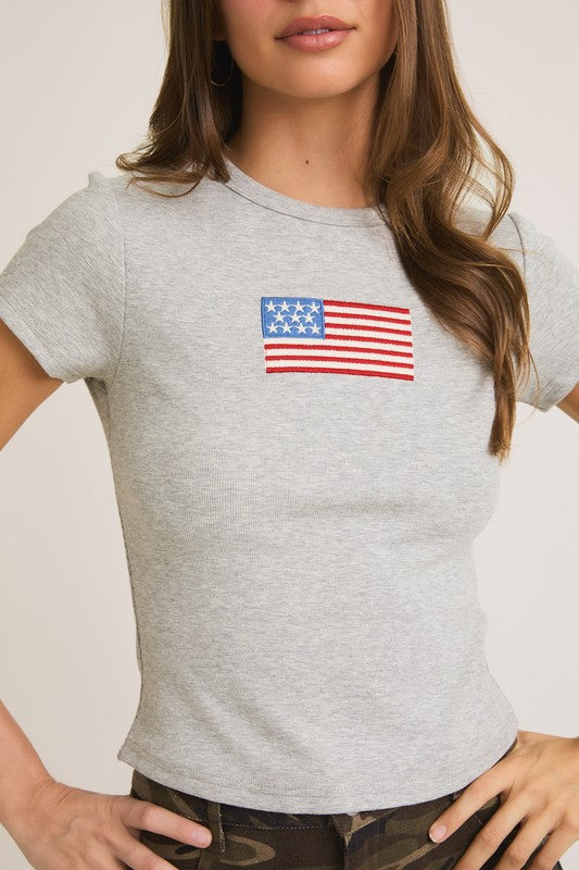 Woman wearing gray t-shirt with American flag.