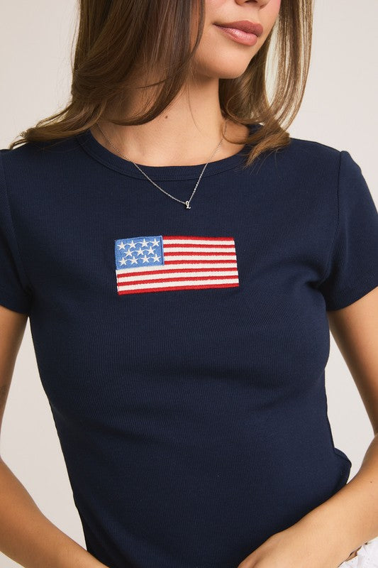 Woman in navy t-shirt with American flag patch.