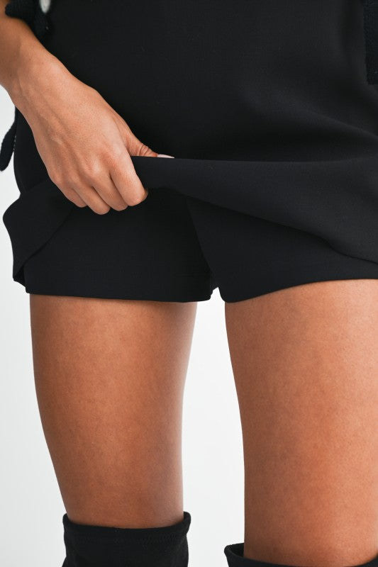 Person wearing black shorts on a white background