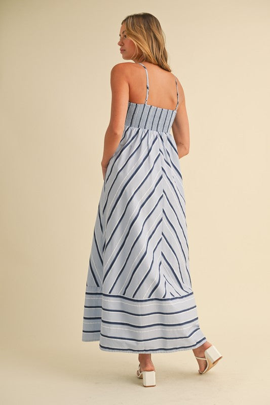 Woman wearing a blue and white striped dress on a beige background