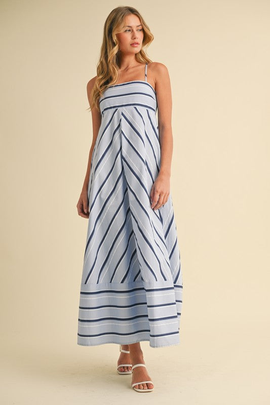 Woman wearing a blue and white striped dress on a beige background