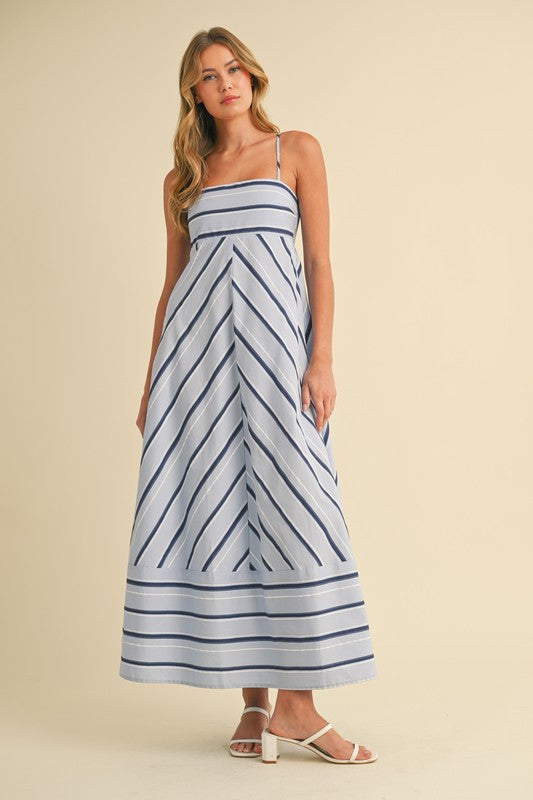Woman wearing a blue and white striped dress on a beige background