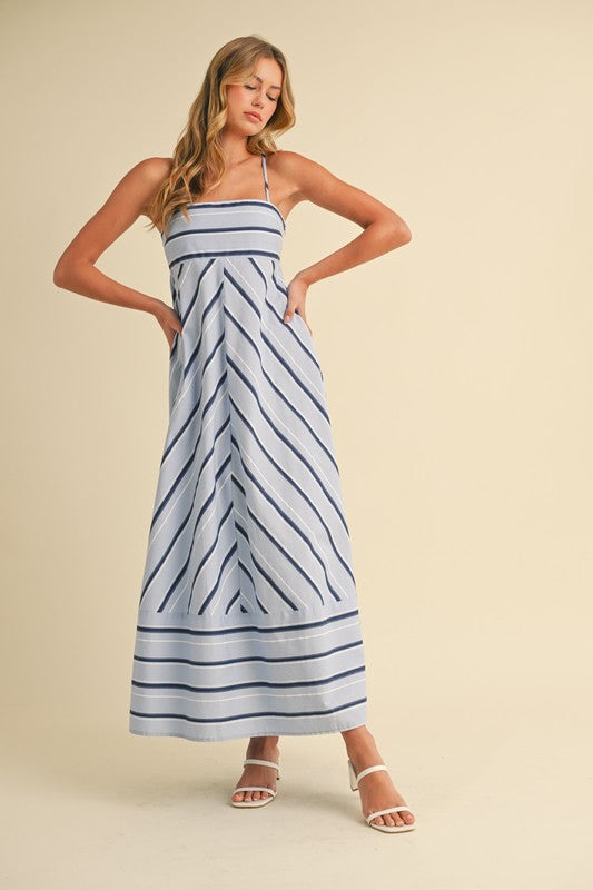 Woman wearing a blue and white striped dress on a beige background