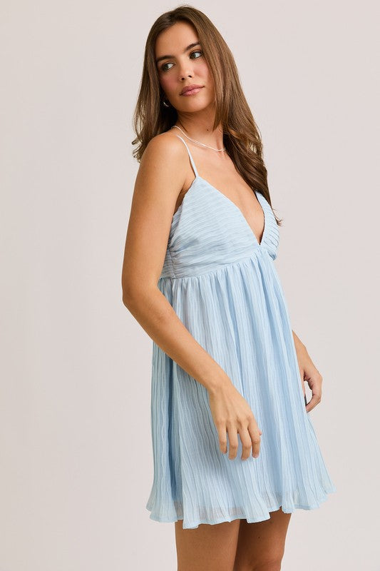 Woman in light blue pleated dress.