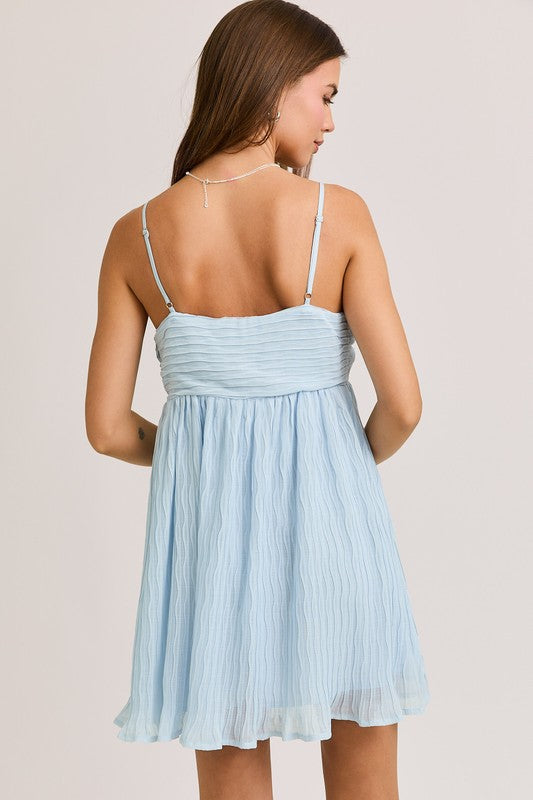 Woman in a light blue sundress from the back.