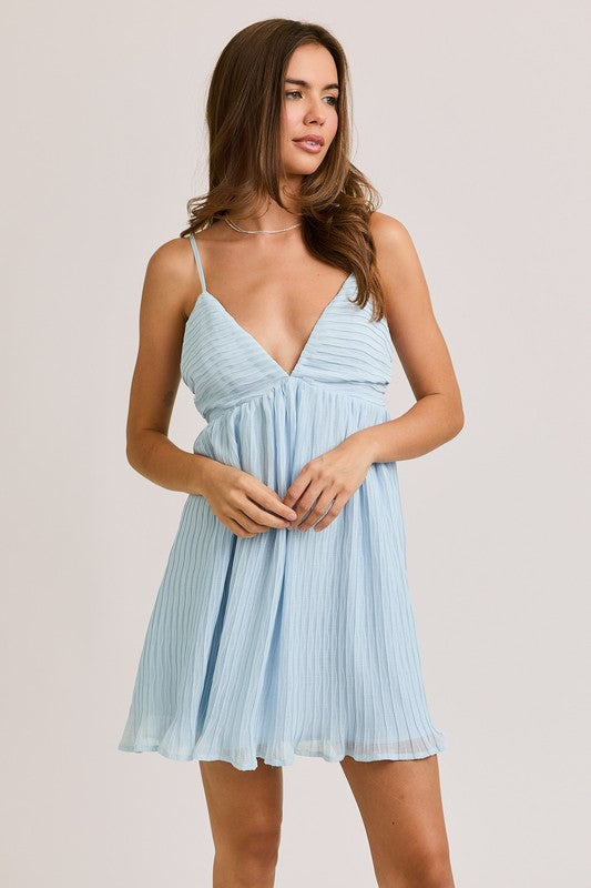 Woman in a light blue pleated dress.