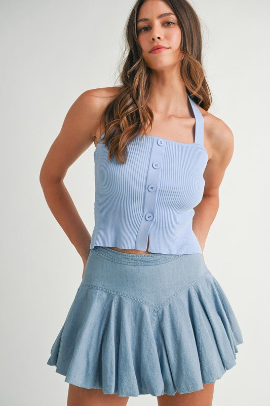 Woman in blue halter top and skirt.