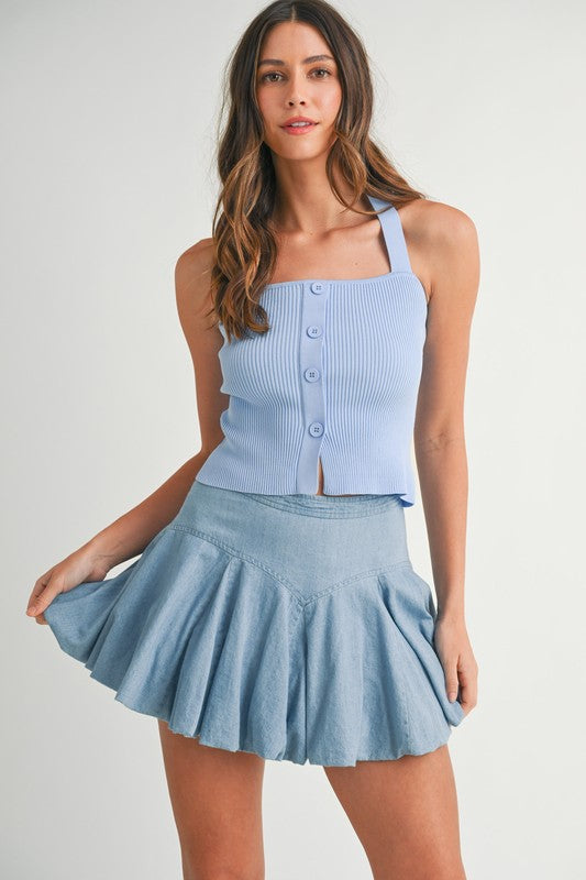 Woman in a blue top and denim skirt.