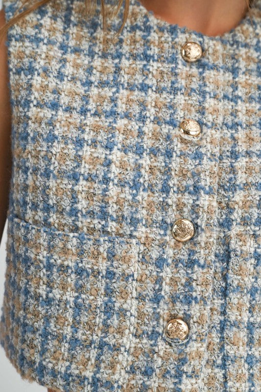 Close-up of a textured fabric with buttons, featuring blue and beige checkered pattern.