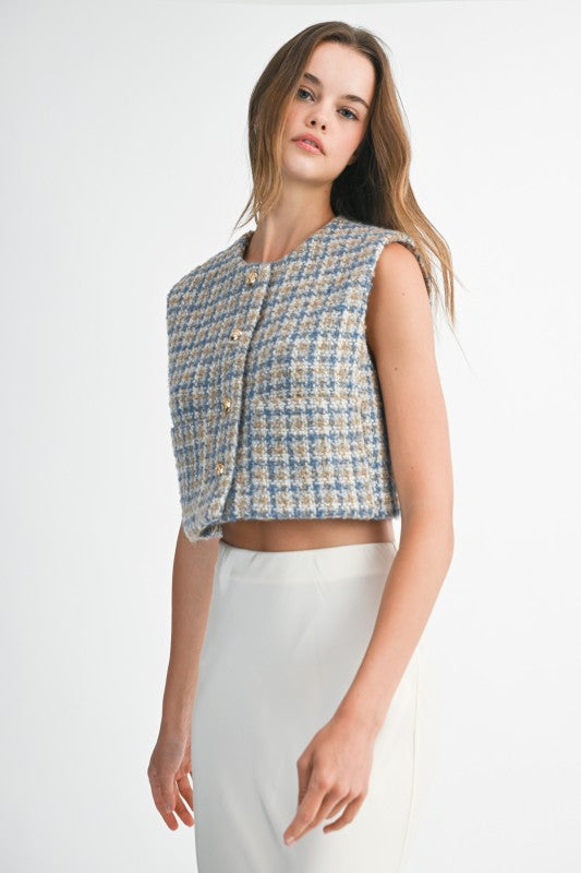 Woman wearing a sleeveless checkered top on a white background