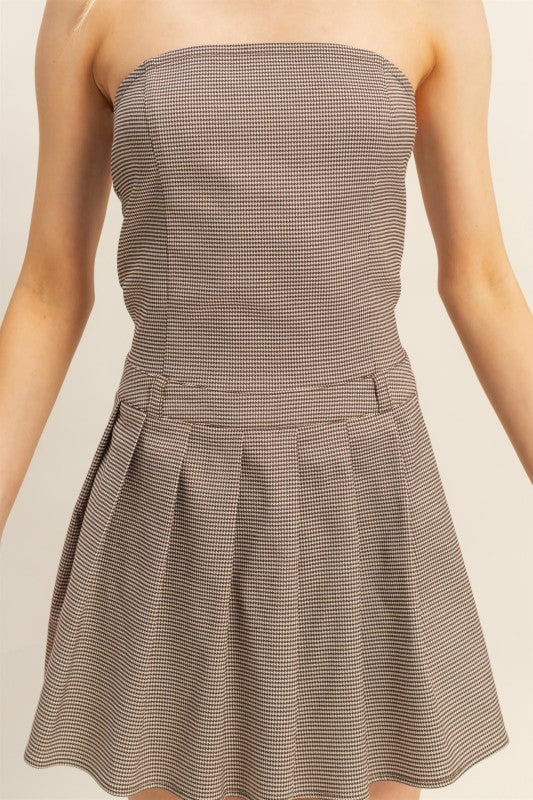Brown strapless dress with a checkered pattern on a neutral background