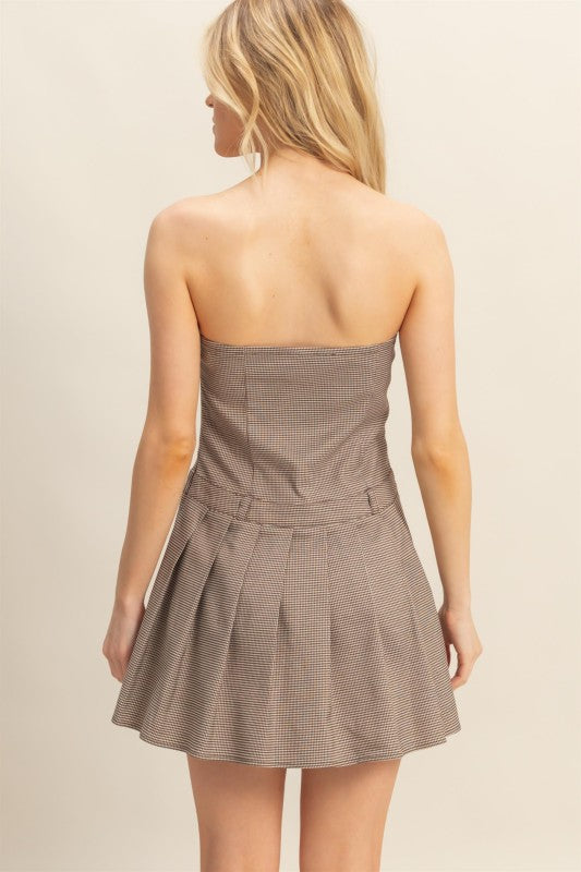 Woman wearing a strapless brown dress with a beige background