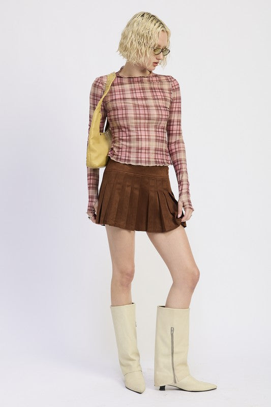 Person wearing a plaid shirt, brown skirt, and beige knee-high boots on a white background