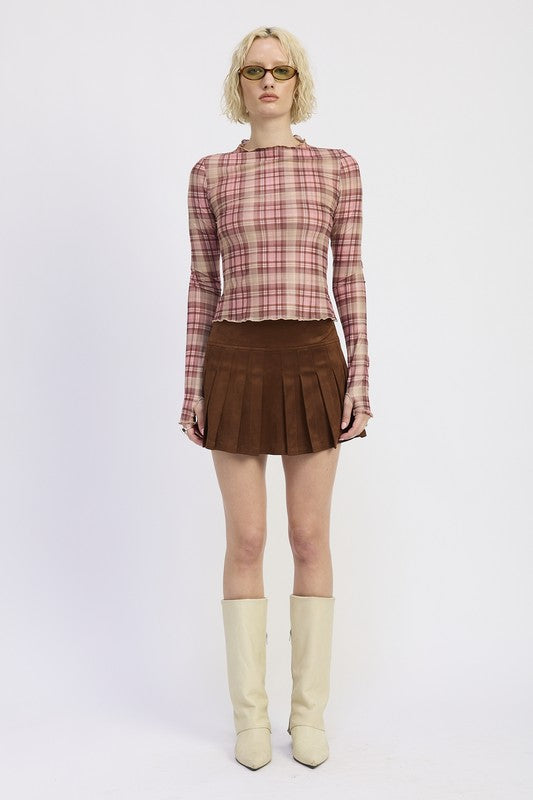 Person wearing a plaid shirt, brown skirt, and white boots on a white background