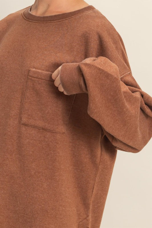 Brown sweatshirt with a pocket on a beige background