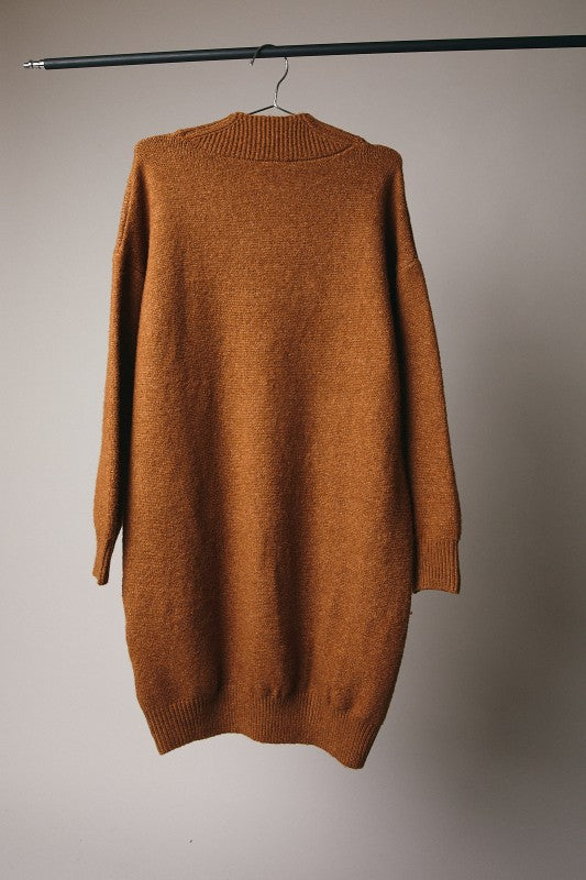 Brown sweater on a hanger against a plain background