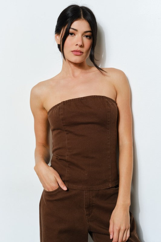 Woman wearing a brown strapless outfit against a white background