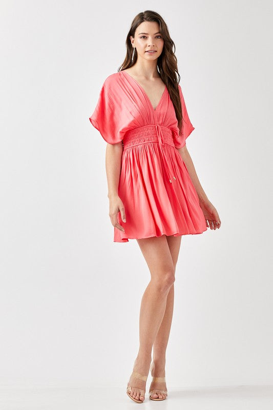 Woman wearing a coral dress on a white background