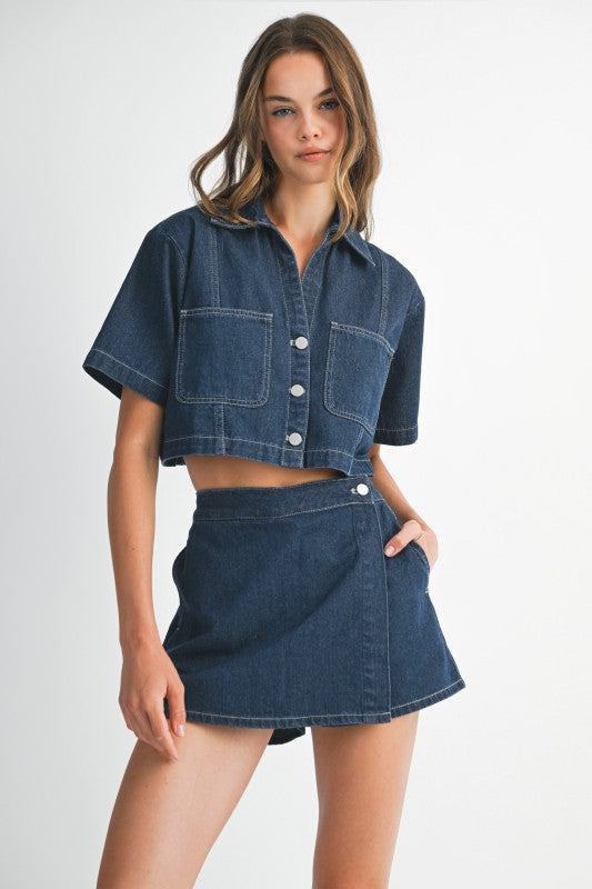 Woman wearing a denim outfit with a jacket and skirt on a white background