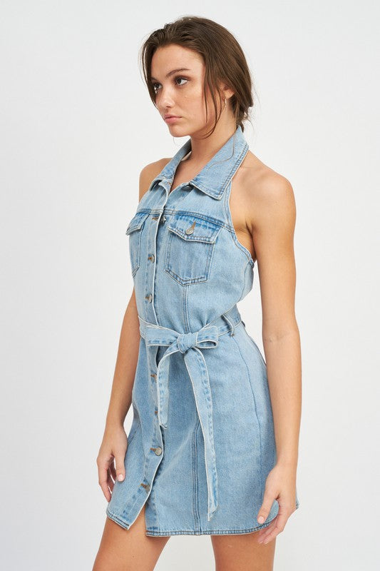 Woman wearing a light blue denim dress on a white background