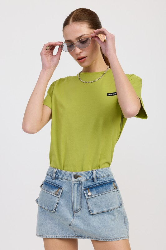 Woman wearing a green t-shirt and denim skirt on a white background