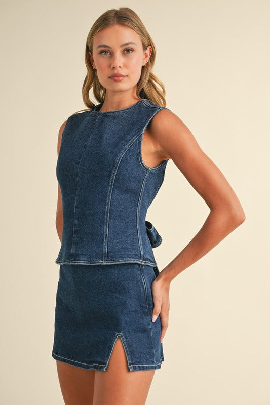 Woman wearing a denim dress with a plain background