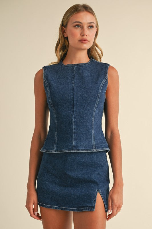 Woman wearing a blue denim dress against a beige background
