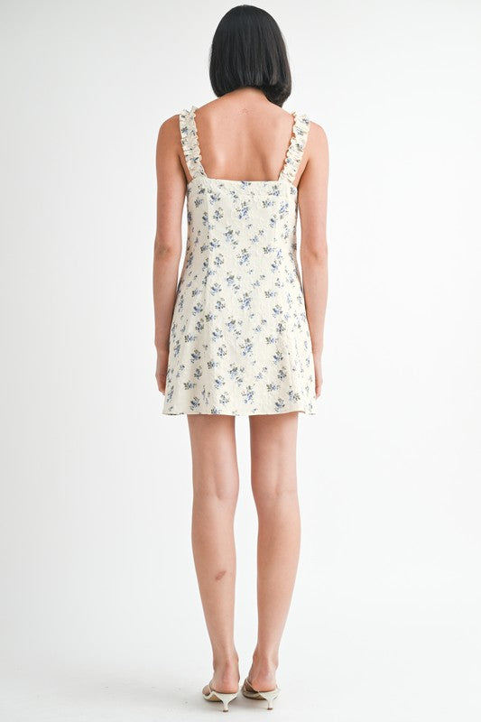 Woman wearing a floral dress with thin straps on a white background