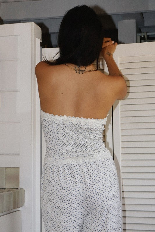 Person wearing a strapless white dress with black polka dots, standing in front of a white cabinet.