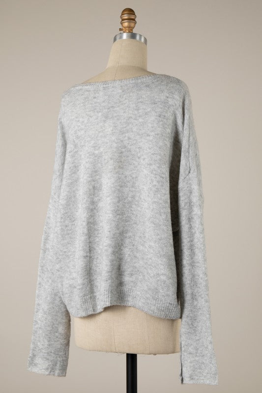 Gray sweater on a mannequin against a beige background