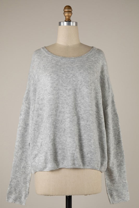 Gray sweater on a mannequin against a beige background