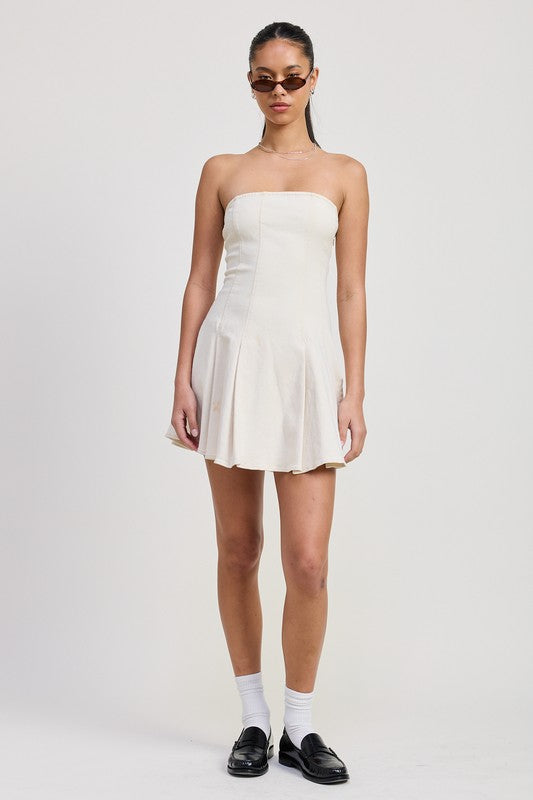 Woman wearing a white strapless dress on a plain background