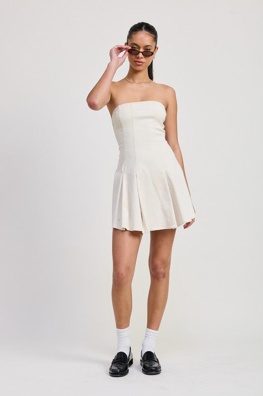 Woman wearing a strapless white dress on a plain background