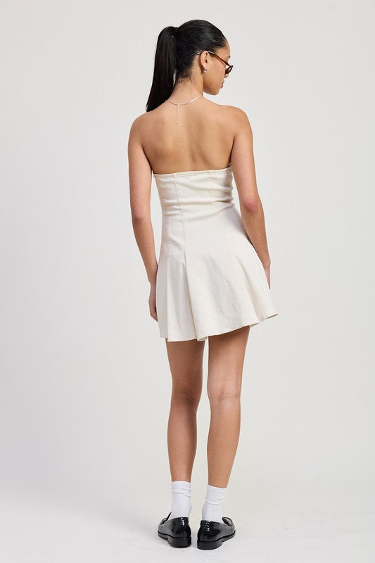 Woman wearing a white strapless dress on a plain background