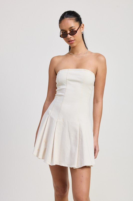 Woman wearing a strapless white dress against a plain background