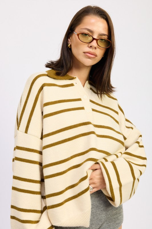 Woman wearing a cream and brown striped sweater on a white background
