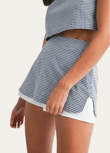 Person wearing a blue and white checkered skirt on a white background
