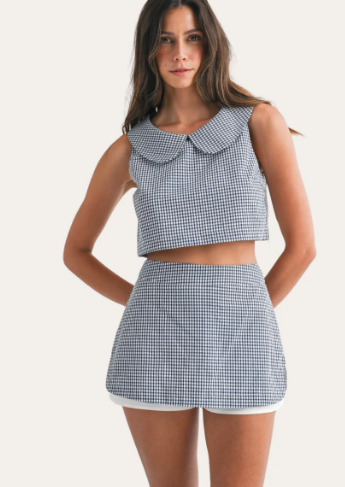 Woman wearing a checkered two-piece outfit on a white background