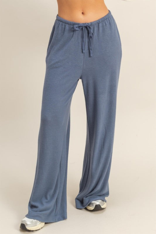 Blue lounge pants worn by a person on a beige background
