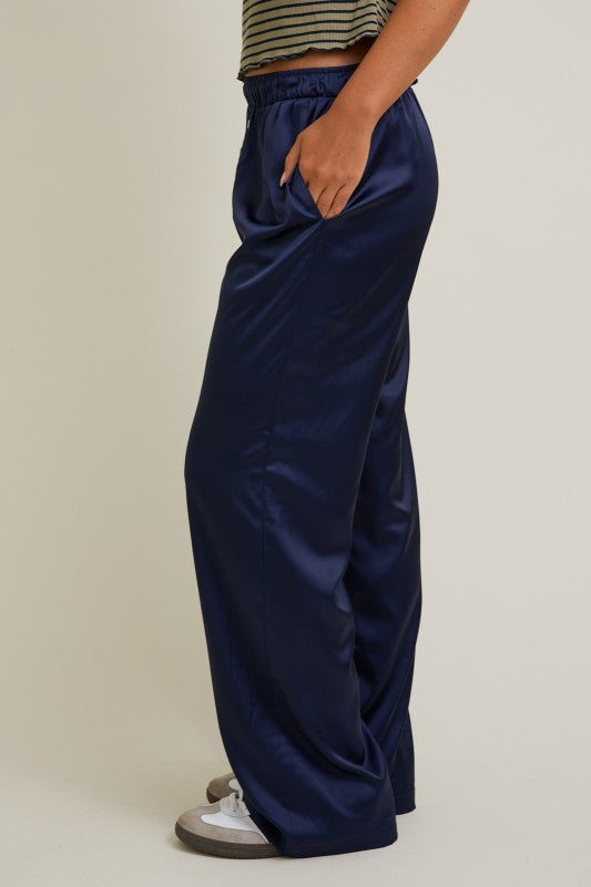 Person wearing navy blue wide-leg pants on a plain background