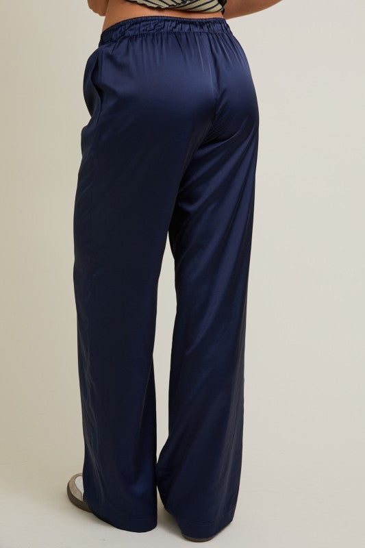 Navy blue wide-leg pants worn by a person on a beige background