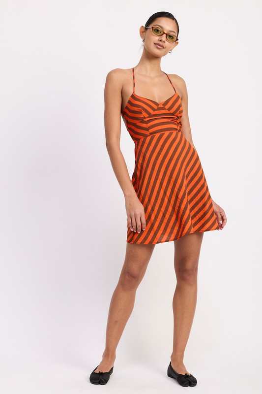 Woman wearing an orange and black striped dress on a white background