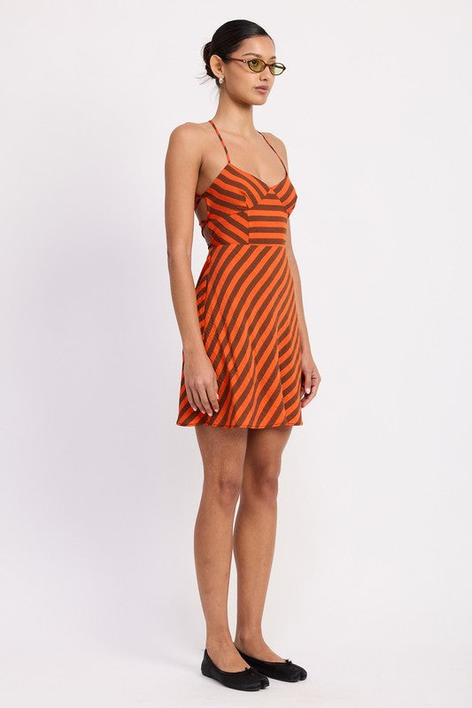 Woman wearing an orange and black striped dress on a white background