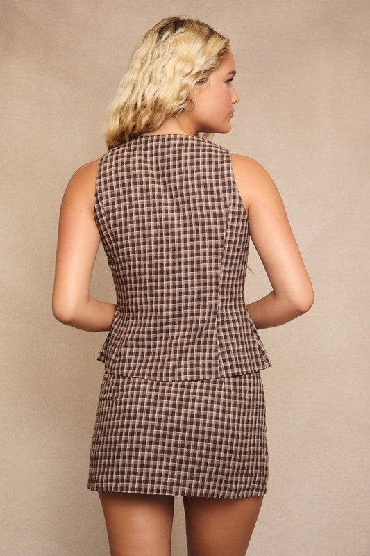 Woman wearing a checkered dress against a beige background
