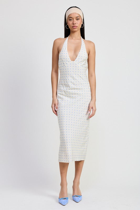 Woman wearing a white patterned dress on a plain background