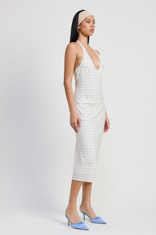 Woman wearing a white patterned dress with a plain background