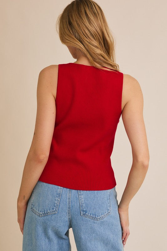 Woman in red tank top and jeans.