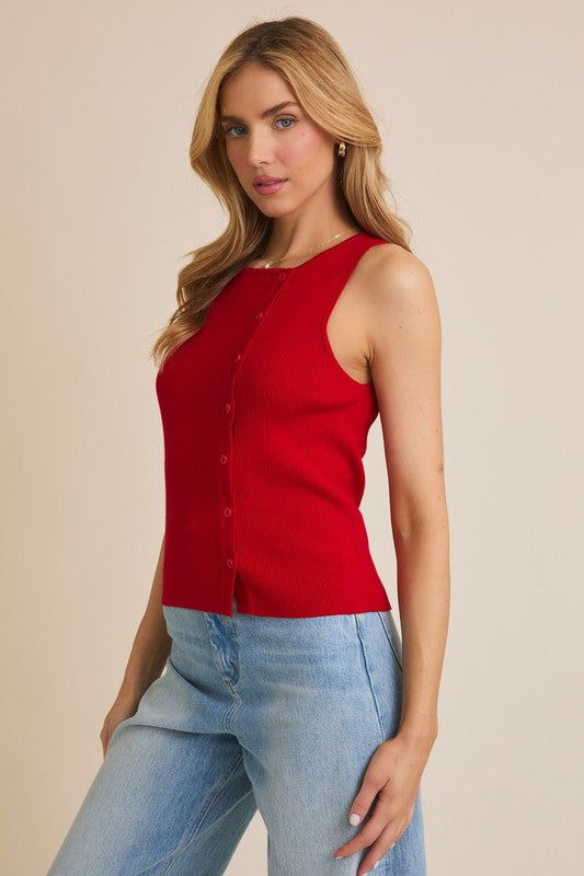 Woman wearing a red button-up tank top and jeans.