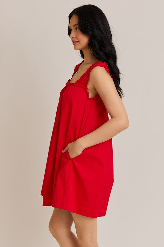 Woman wearing a red dress against a plain background